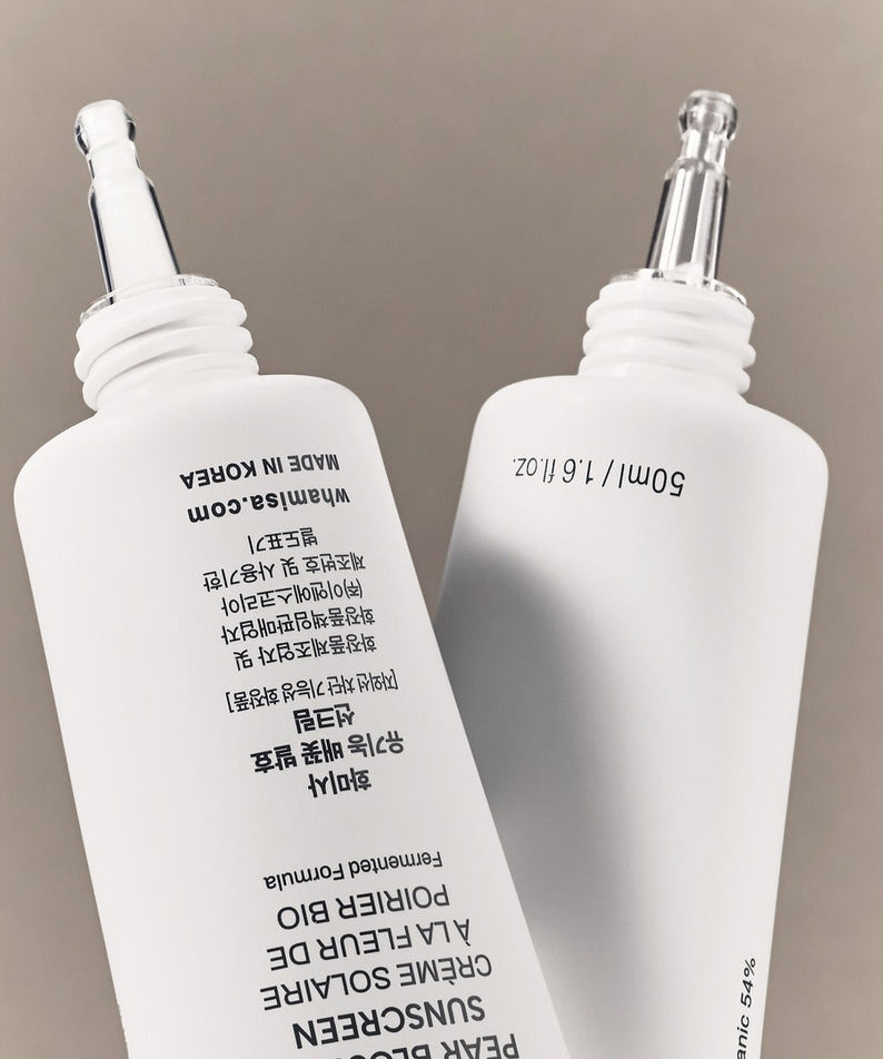 WHAMISA Organic Pear Blossom Fermented Sunscreen 50ml : flacons blancs sur fond beige, marque WHAMISA en gros.