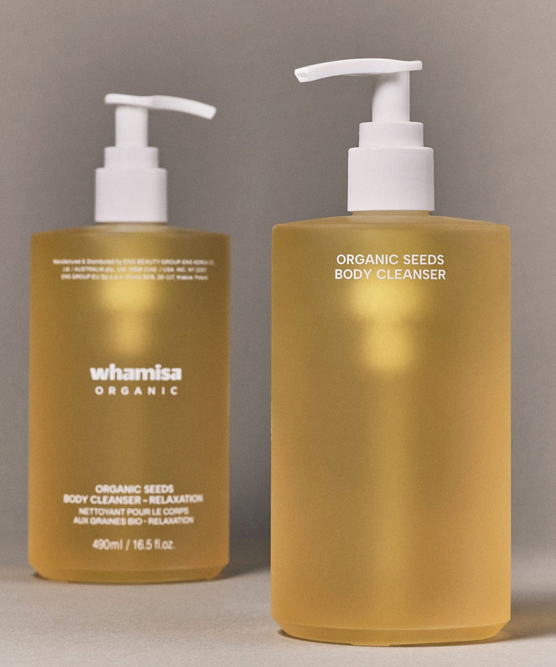 Décris l’image en français : WHAMISA Organic Seed Fermented Body Cleanser 490ml, deux flacons dorés avec pompes sur fond neutre.