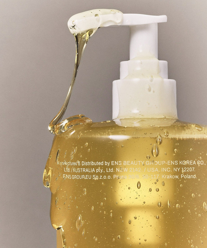 WHAMISA Organic Seed Fermented Body Cleanser 490ml : flacon blanc et texture dorée, contexte bain/douche, marque WHAMISA
