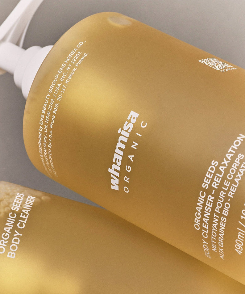 WHAMISA Organic Seed Fermented Body Cleanser 490ml, flacon jaune WHAMISA sur salle de bain, packaging visible, gros plan
