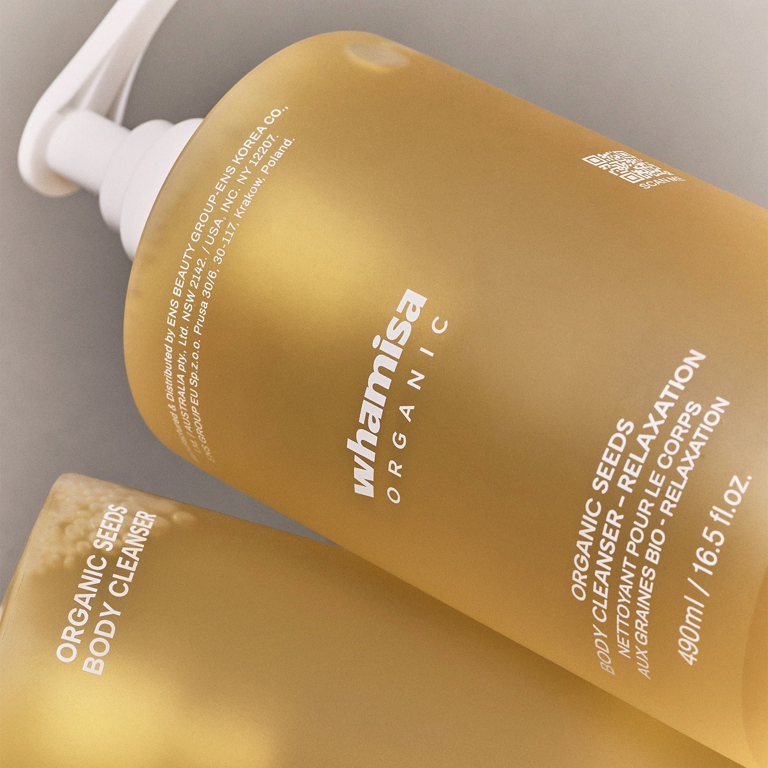 WHAMISA Organic Seed Fermented Body Cleanser 490ml, flacon jaune WHAMISA sur salle de bain, packaging visible, gros plan