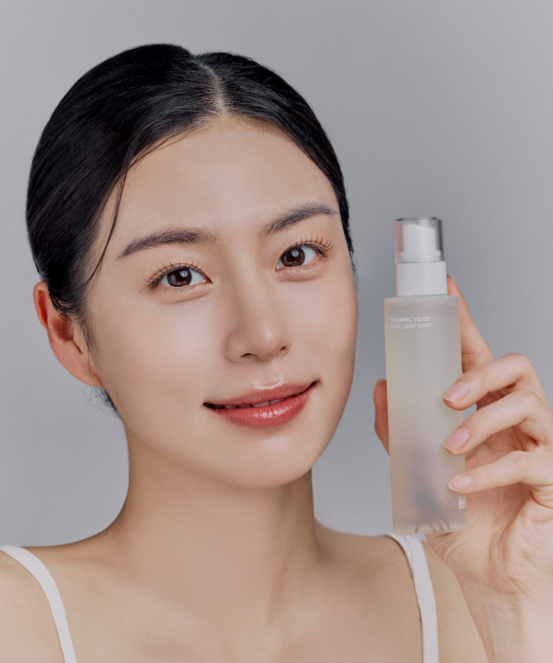 Femme tenant WHAMISA Organic Herb Fermented Olive Leaf Mist 100ml, soin de beauté naturel