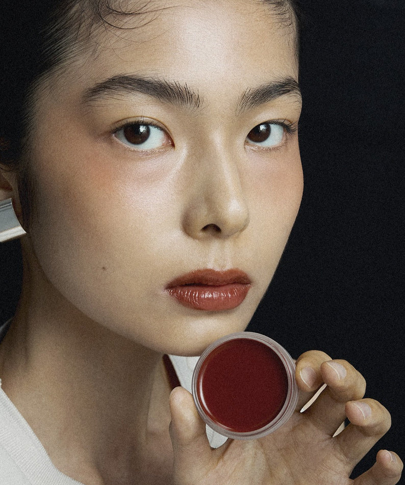 Une femme tenant un pot de XOUL Ever Moist Volume Lip Balm 8g, un baume à lèvres hydratant et volumateur, idéal pour une hydratation intense.