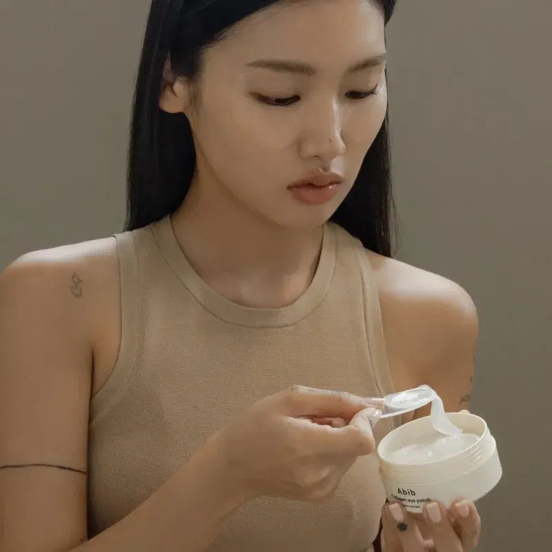 Décris l'image en français : ABIB Collagen Eye Patch Jericho Rose Jelly 90g, patches sous sachet, femme aux yeux, soin beauté.