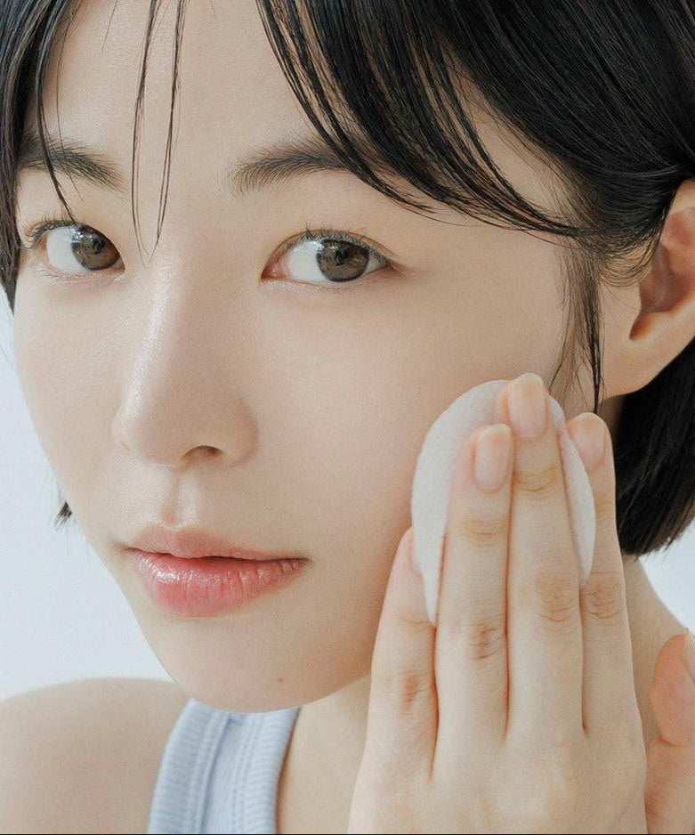 ABIB Sedum Hyaluron Pad Hydrating Touch 75p 165ml : jeune femme applique un pad hydratant sur le visage, gros plan.