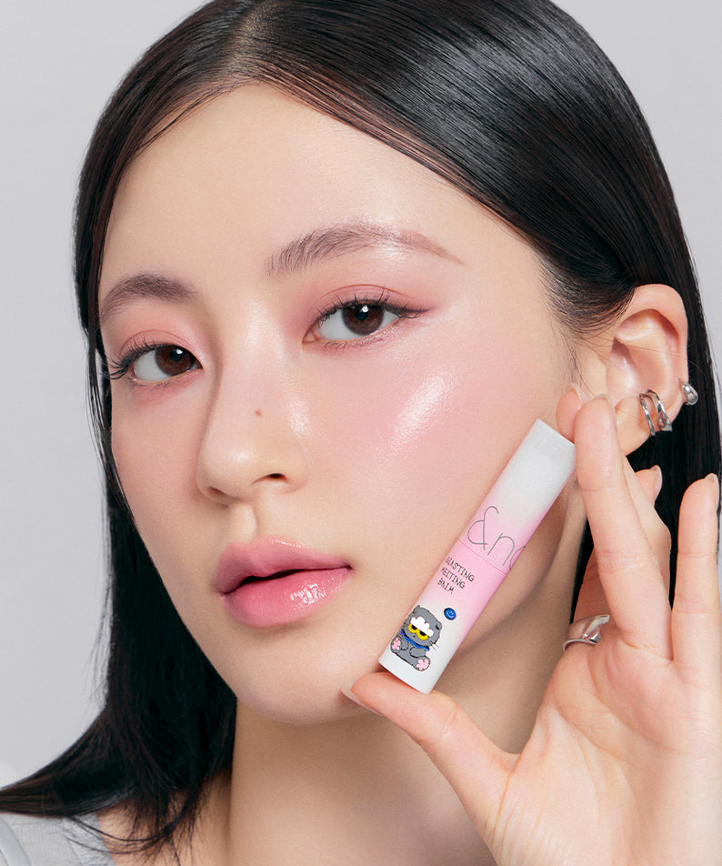 ROMAND x Joanne Friends Glasting Melting Balm tenue par une femme, maquillage rose brillant, produit de beauté tendance.