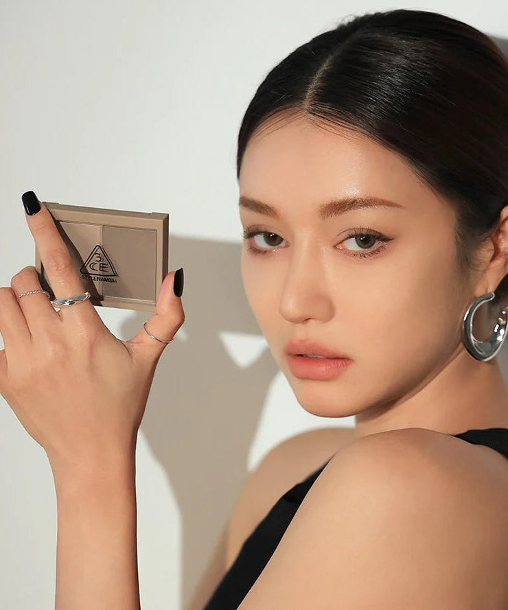 3CE Contour Shading, maquillage de contour 3CE appliqué sur le visage d’une mannequin, fond studio clair, vue rapprochée.