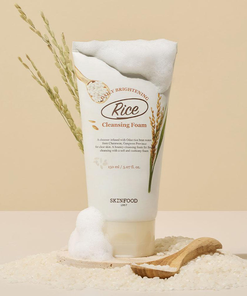 SKINFOOD Rice Daily Brightening Scrub Foam 150ml, moussant, sur fond beige avec riz et blé, marque SKINFOOD