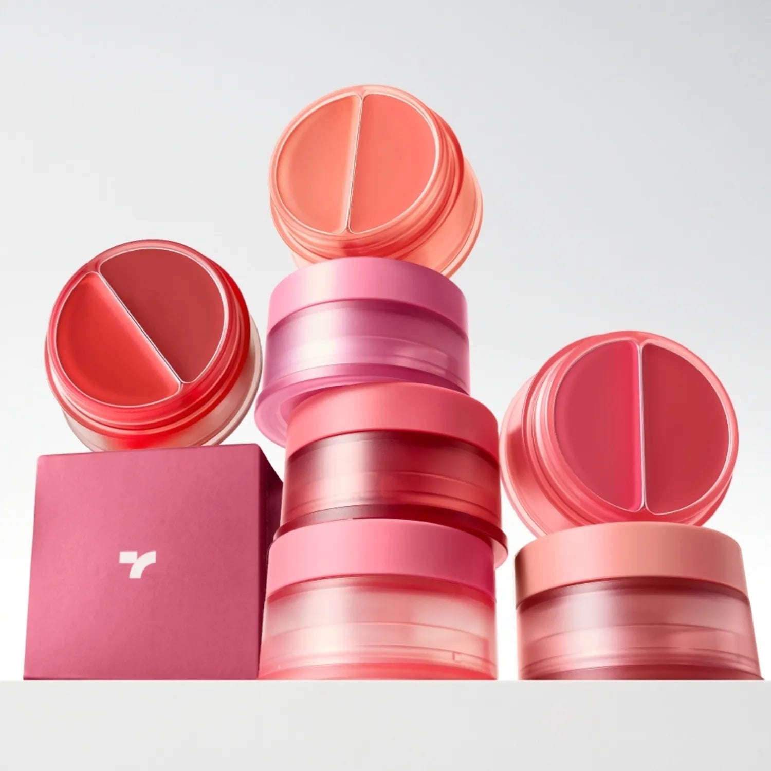 Décris l'image en français : TONY MOLY Cheek Tone Lip & Cheek Duo Balm, baume lèvres et joues, marques et couleurs rose/rouge sur fond clair.