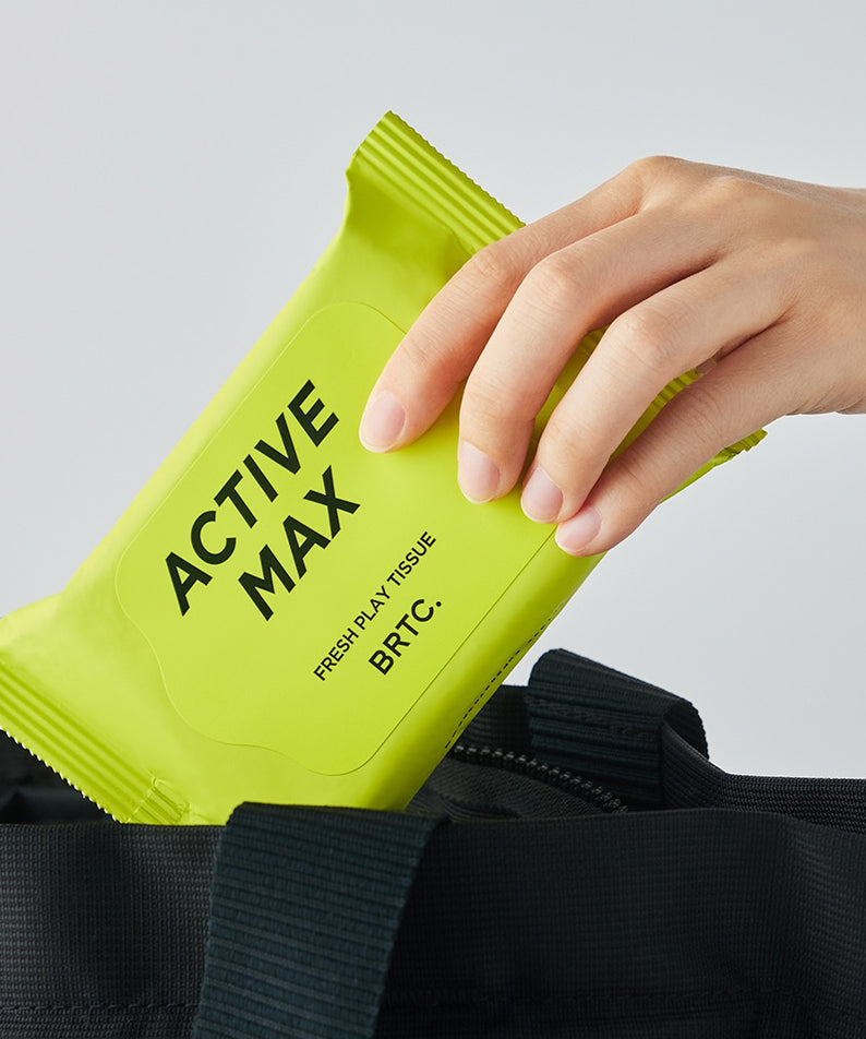 BRTC Homme Active Max Fresh Play Tissue 15 Sheets en main sortant d'un sac noir, emballage vert vif, 15 feuilles.