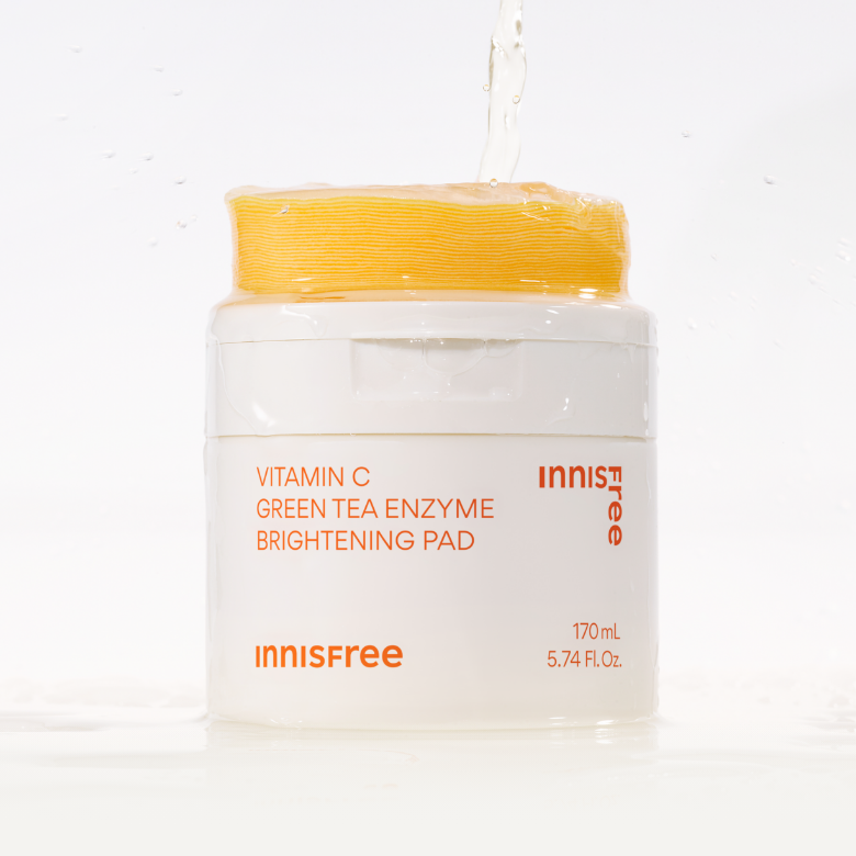 INNISFREE Vitamin C Green Tea Enzyme Brightening Pad 60p 170ml, pot blanc avec splash d’eau, marque INNISFREE, fond clair.