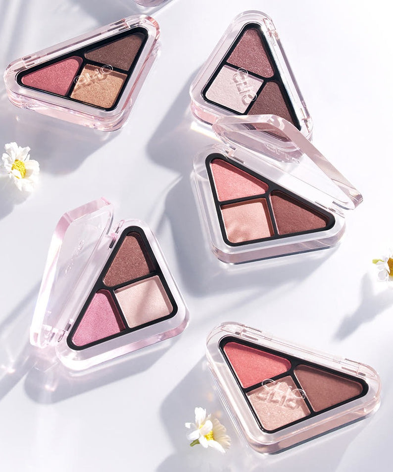 Palette de fards à paupières tricolores CLIO Essentail Shadow Tab emballées sur fond blanc avec petites fleurs blanches.