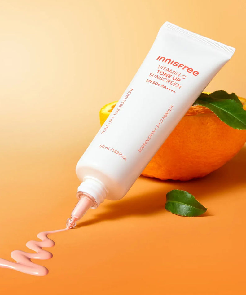 INNISFREE Vita C Spot Tone Up Sunscreen SPF50+/PA++++ 50ml : tube crème solaire Innisfree sur fond orange, mangue et feuilles