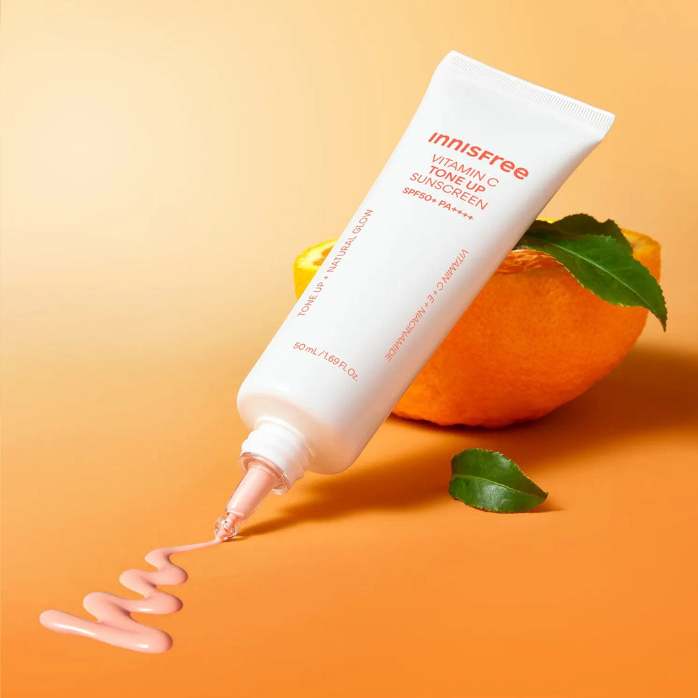 INNISFREE Vita C Spot Tone Up Sunscreen SPF50+/PA++++ 50ml : tube crème solaire Innisfree sur fond orange, mangue et feuilles