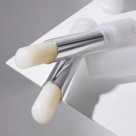 INNISFREE Dewy Treatment Lip Balm 3.2g, marque Innisfree, baume lèvres sur fond blanc et gris, tube et applicateur visibles.