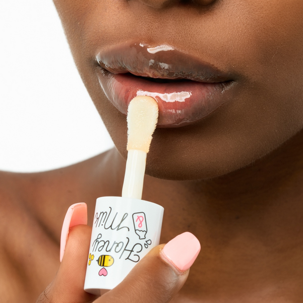 A'PIEU Honey&Milk Lip Oil, huile pour les lèvres de la marque A'PIEU appliquée sur des lèvres, fond blanc.