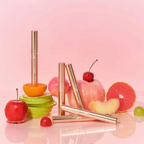TONY MOLY Get It Tint Glaze Balm, baume teint brillant sur fond rose avec fruits (cerise, pamplemousse). Marque TONY MOLY