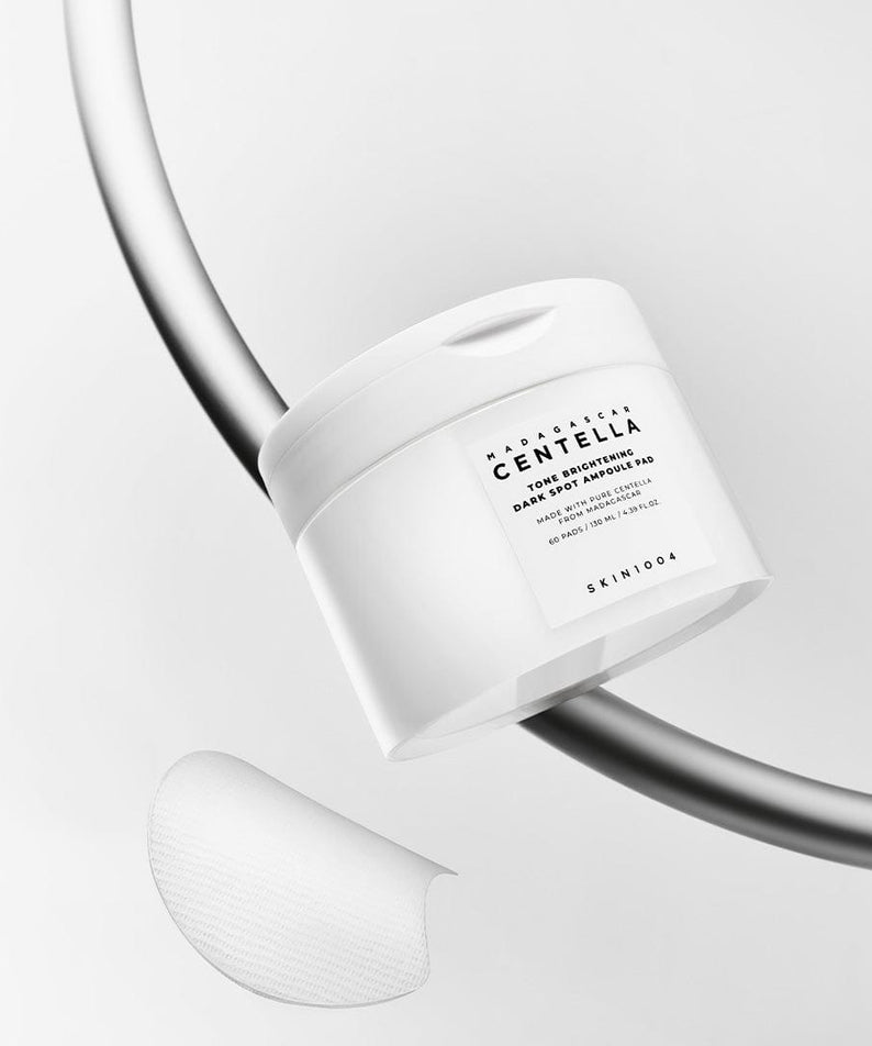 SKIN1004 Madagascar Centella Tone Brightening Dark Spot Ampoule Pads (60 sheets) sur un fond minimaliste.