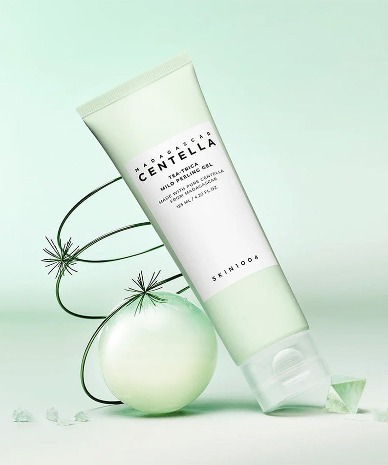 SKIN1004 Madagascar Centella Tea-trica Mild Peeling Gel 125ml, gel exfoliant doux sur fond vert avec décoration élégante en sphère.