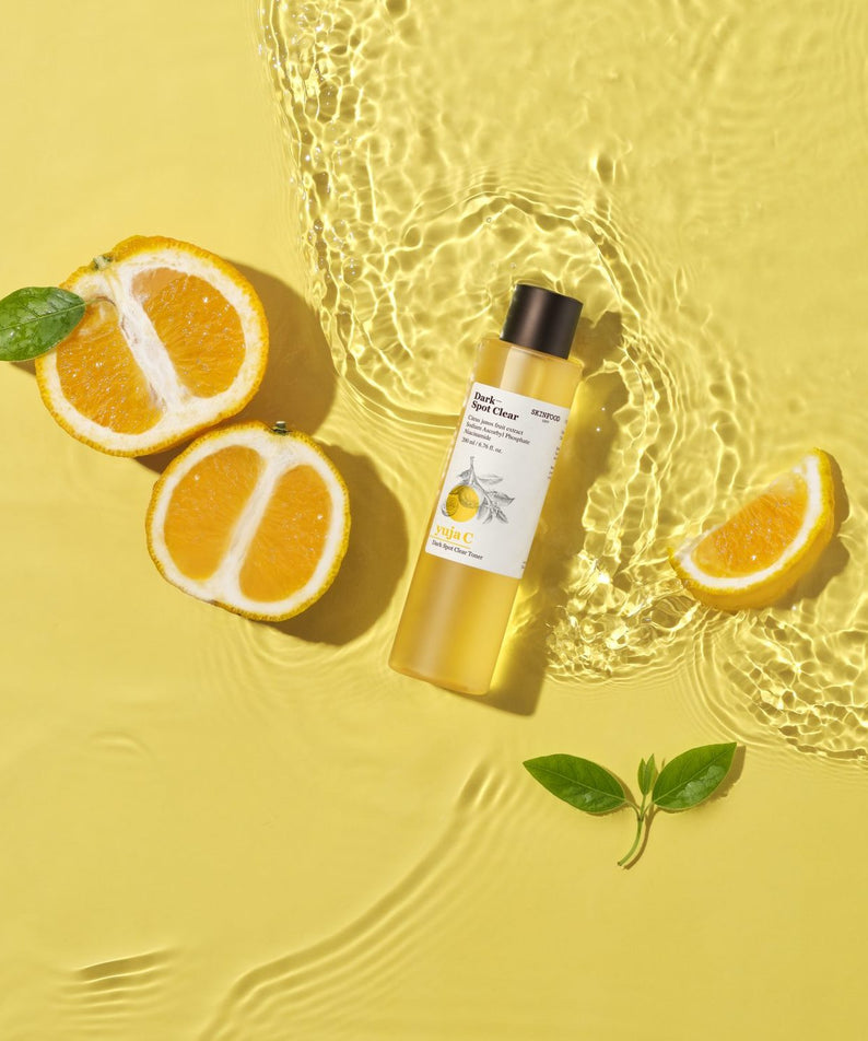 SKINFOOD Yuja C Dark Spot Clear Toner 200ml de SKINFOOD, flacon jaune sur fond jaune avec tranche d’agrume et bulles