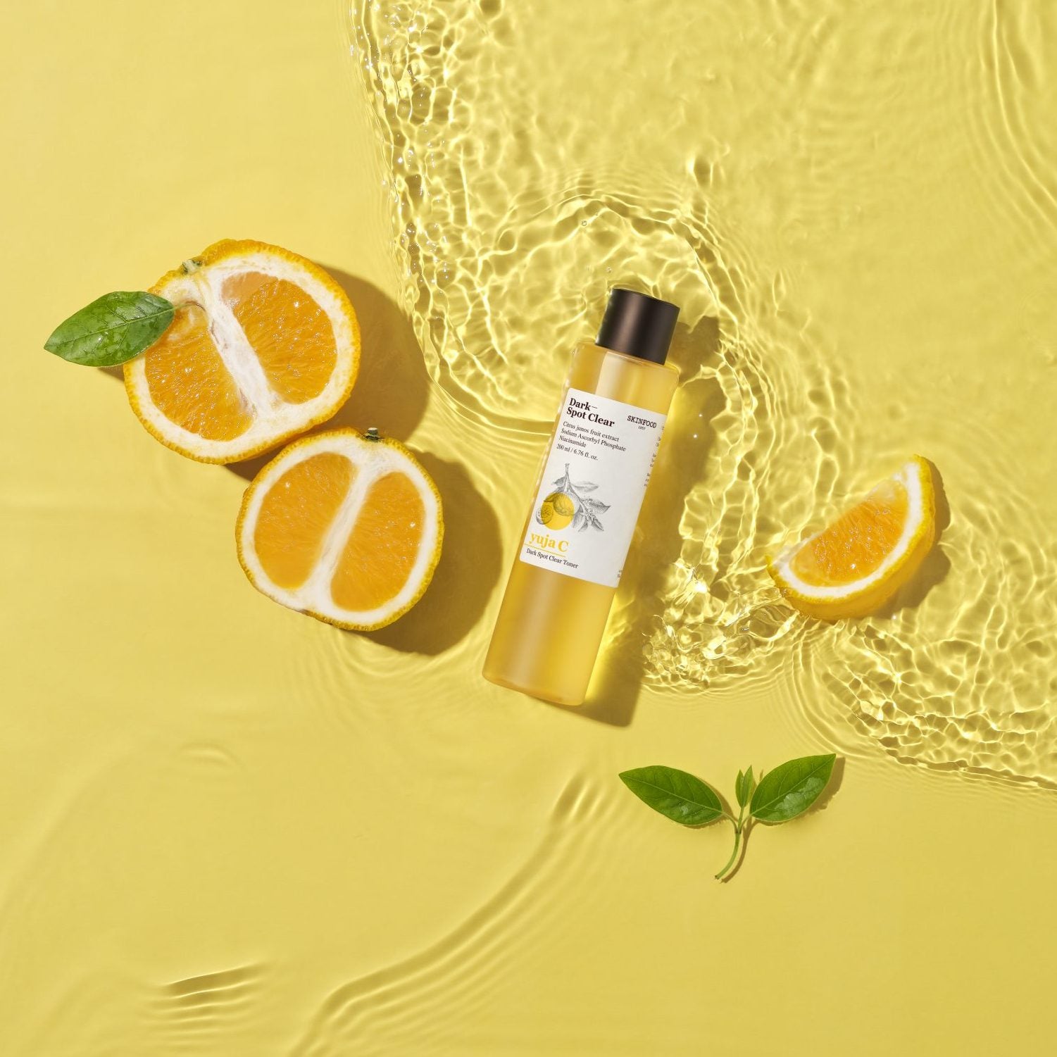 SKINFOOD Yuja C Dark Spot Clear Toner 200ml de SKINFOOD, flacon jaune sur fond jaune avec tranche d’agrume et bulles