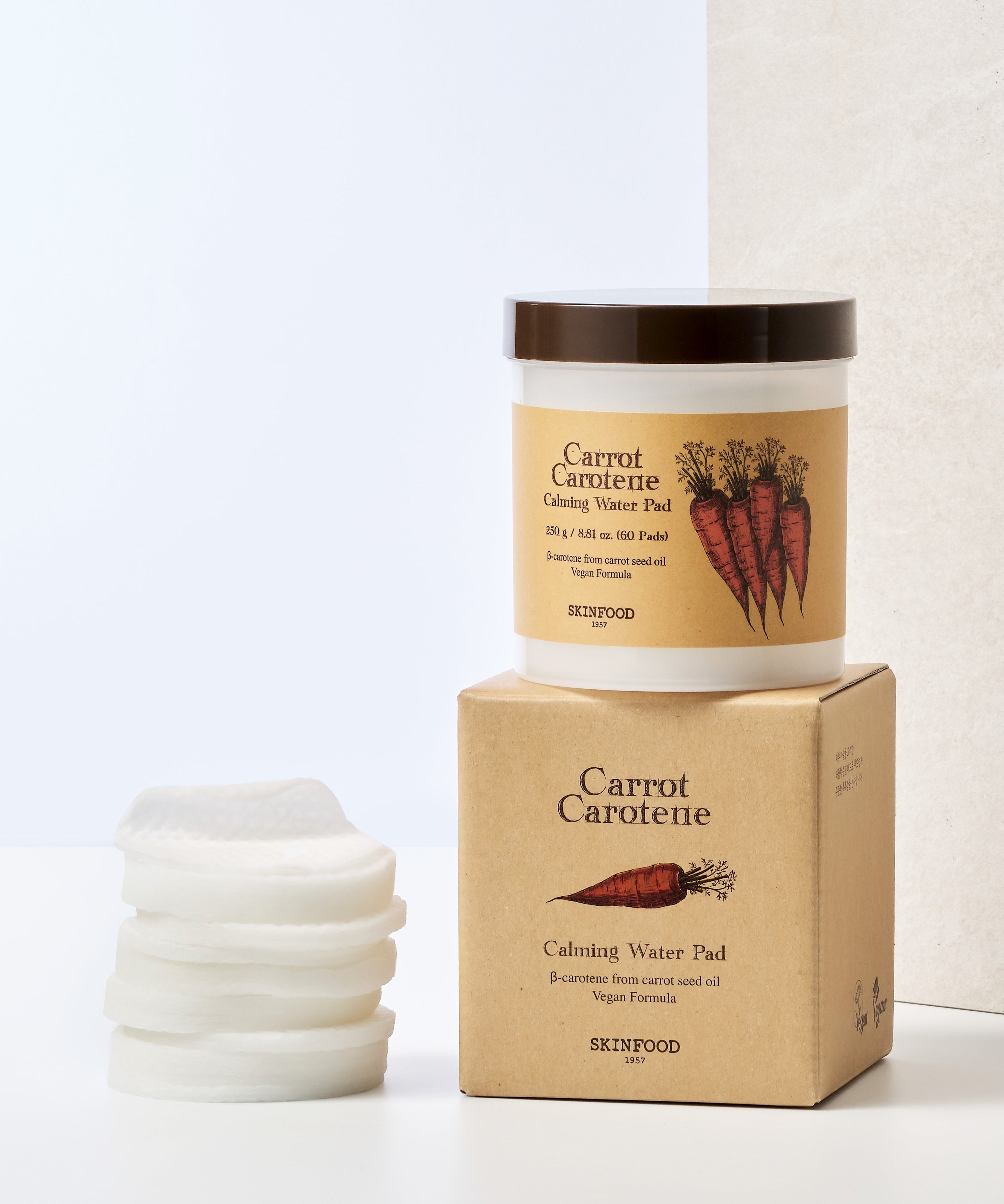 SKINFOOD Carrot Carotene Calming Water Pad de la marque SKINFOOD, pack et pads sur fond beige, mise en scène produit