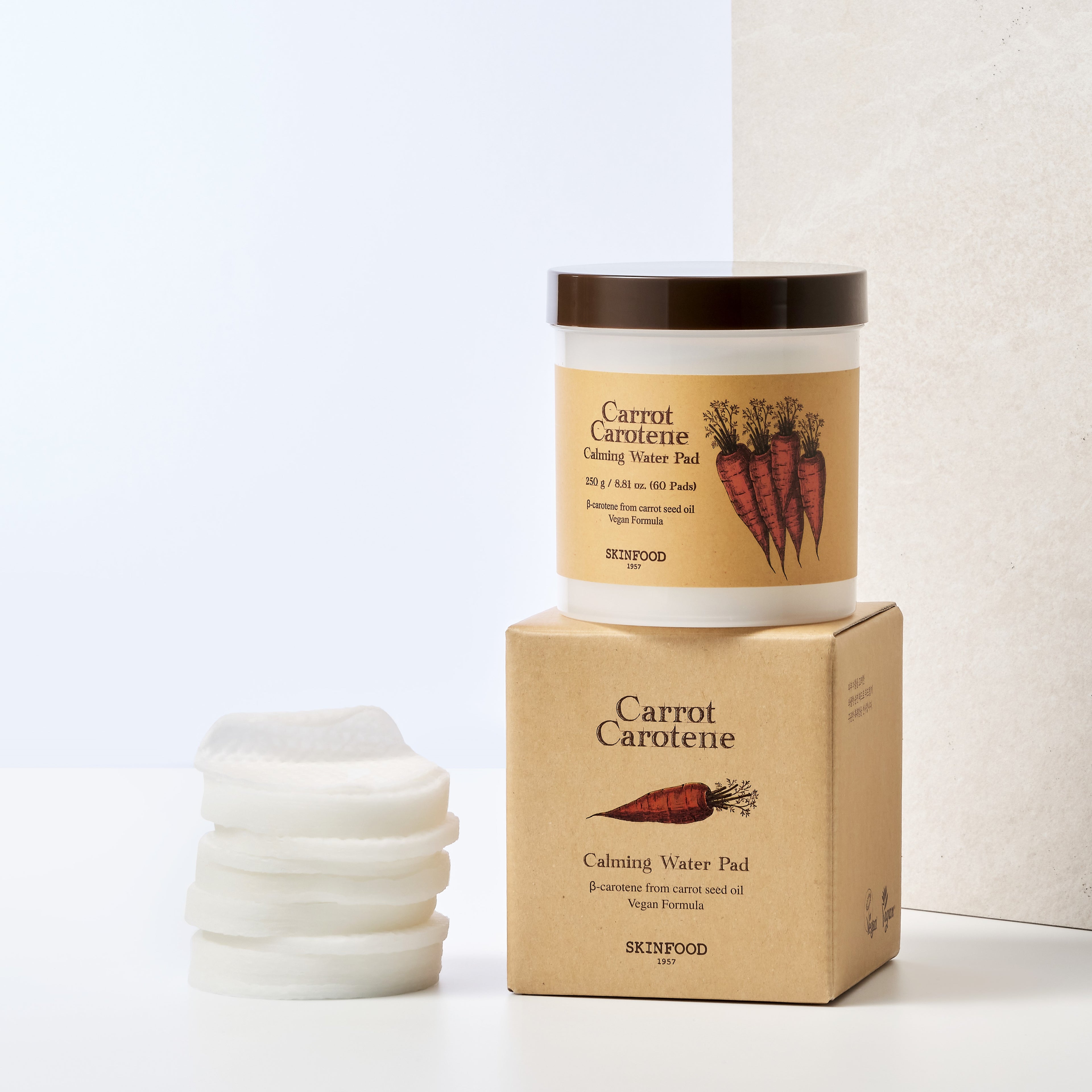 SKINFOOD Carrot Carotene Calming Water Pad de la marque SKINFOOD, pack et pads sur fond beige, mise en scène produit