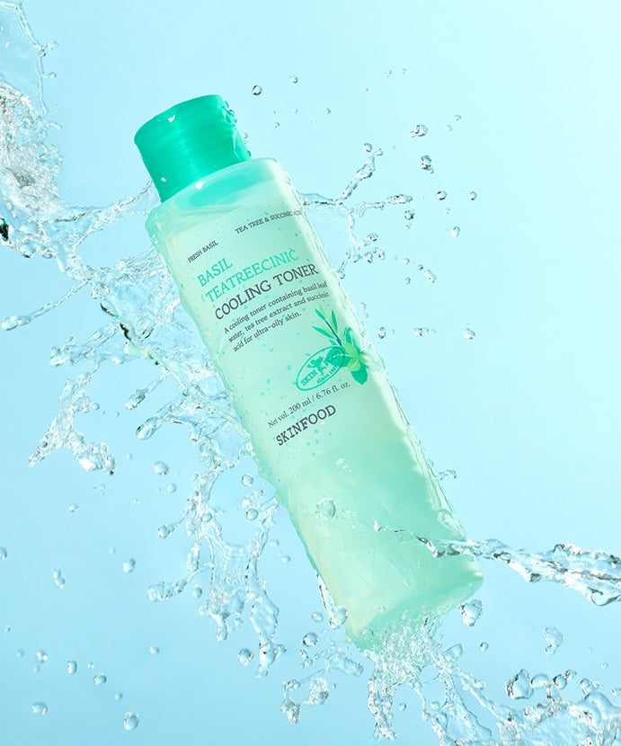 Tonique rafraîchissant SKINFOOD Basil Tea Tree Cynic Cooling Toner 200ml en action avec éclaboussures d'eau, produit de soin visage.