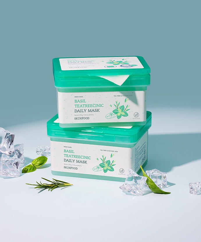 Masque SKINFOOD [NEW] Basil Tea Tree Cynic Daily Mask 30 Sheets avec feuilles de basilic et glace autour, sur fond bleu.