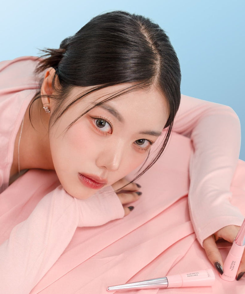 Femme pose avec NEOGEN Slim Metal Mascara 6ml, maquillage délicat et tube élégant en métal, illustration de beauté féminine moderne.