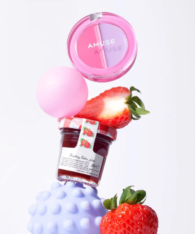 AMUSE Lip & Cheek Healthy Balm de la marque AMUSE, baume pour lèvres et joues, sur fond clair avec fraises et pétales roses.