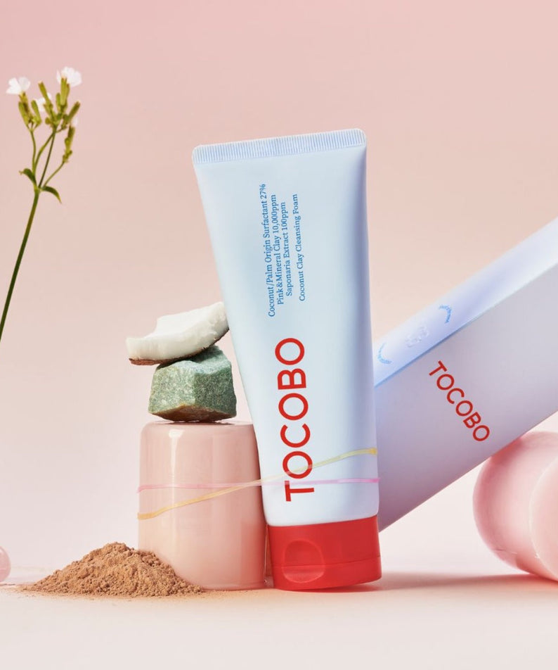 TOCOBO  Coconut Clay Cleansing Foam, flacon crème sur fond rose pastel avec ingrédients cosmétiques et fleurs, marque TOCOBO
