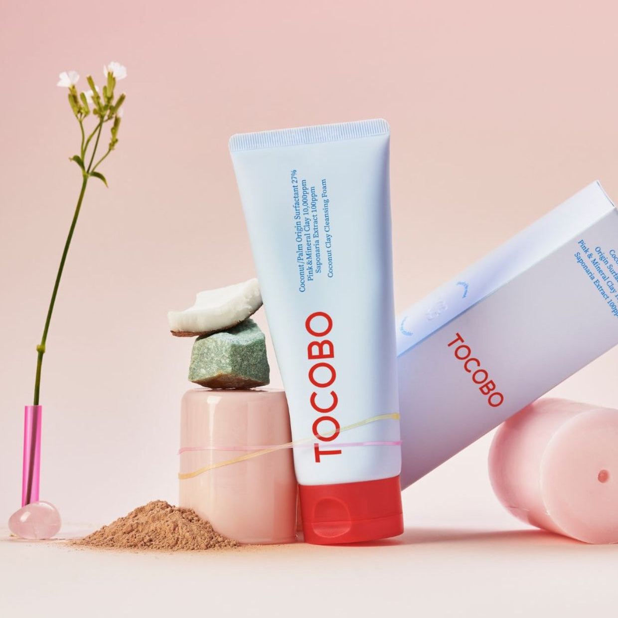 TOCOBO  Coconut Clay Cleansing Foam, flacon crème sur fond rose pastel avec ingrédients cosmétiques et fleurs, marque TOCOBO