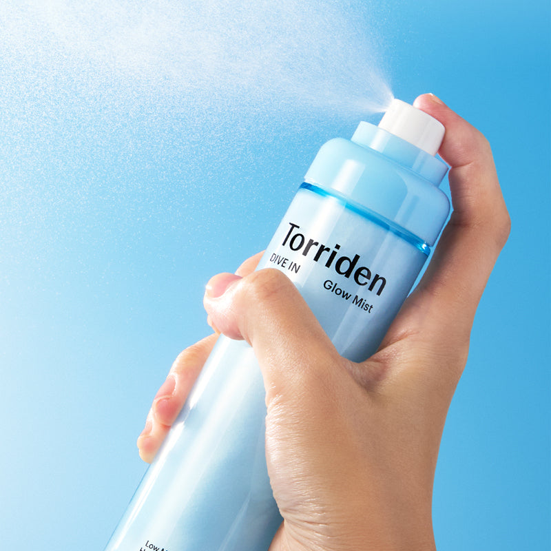 TORRIDEN Dive-in Low Molecular Hyaluronic Acid Cream Mist 120ml, main tenant le flacon sur fond bleu aquatique.